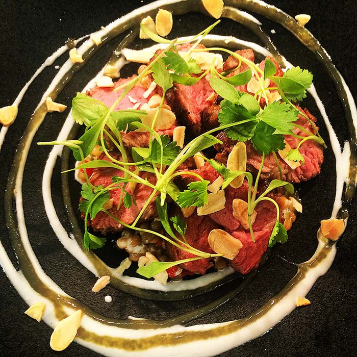 Poached lamb neck israeli cous cous preserved lemon yoghurt and coriander cress